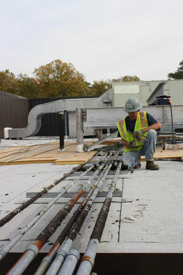 In this photo, a construction crew member works on changing the piping to the energy towers on the Earl Gregg Swem Library roof. These updates will make room for an additional tower to will accommodate the new energy needs of the future ISC 3.  BAILEY KIRKPATRICK / THE FLAT HAT